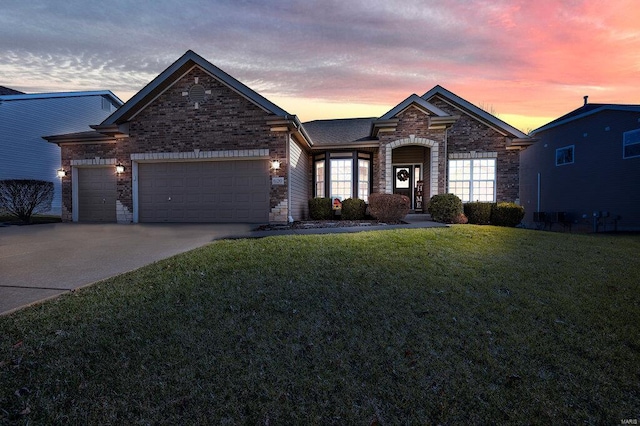 view of front of home with a garage and a lawn