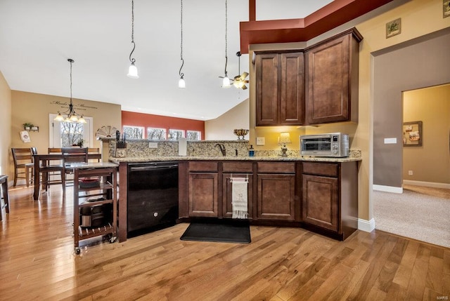 kitchen featuring decorative light fixtures, dishwasher, a chandelier, and light stone countertops