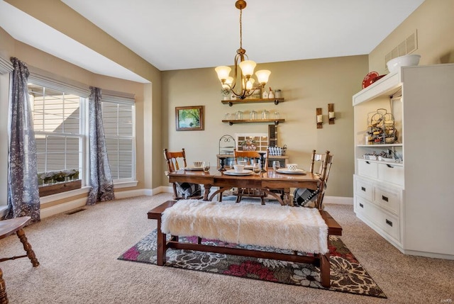 carpeted dining space featuring a notable chandelier