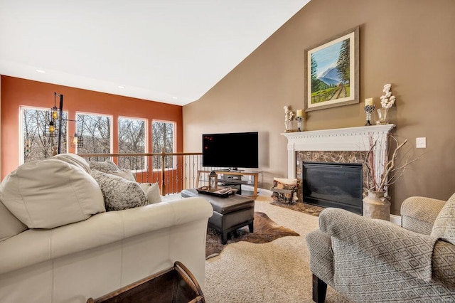 living room featuring lofted ceiling, a high end fireplace, and carpet floors