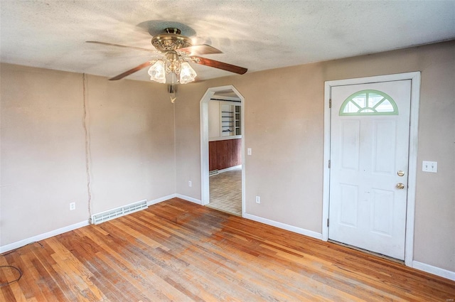 foyer entrance featuring ceiling fan, a textured ceiling, and light wood-type flooring