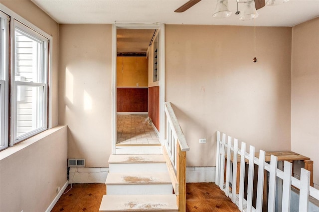 stairway featuring ceiling fan and parquet floors