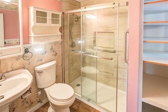 bathroom featuring sink, a shower with door, wood-type flooring, and toilet