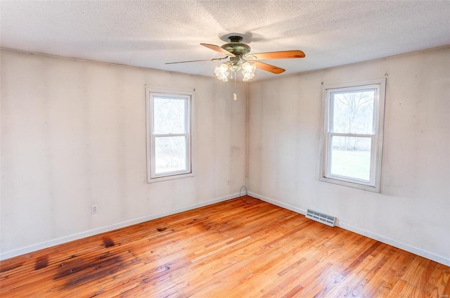 spare room featuring ceiling fan, light hardwood / wood-style floors, and a textured ceiling