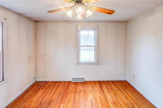 empty room with ceiling fan and light hardwood / wood-style flooring