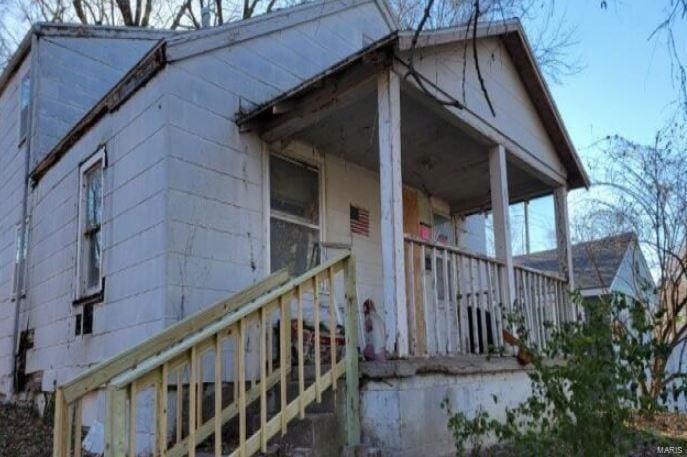 view of side of property featuring covered porch