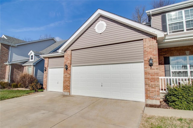 view of front of home with an attached garage, concrete driveway, and brick siding