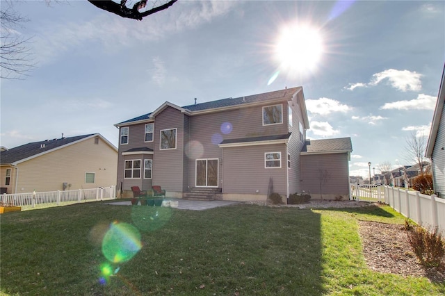 rear view of house featuring a patio, a lawn, and a fenced backyard