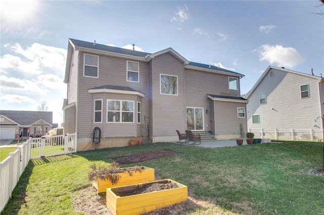 rear view of property with a garden, a fenced backyard, a lawn, and a patio