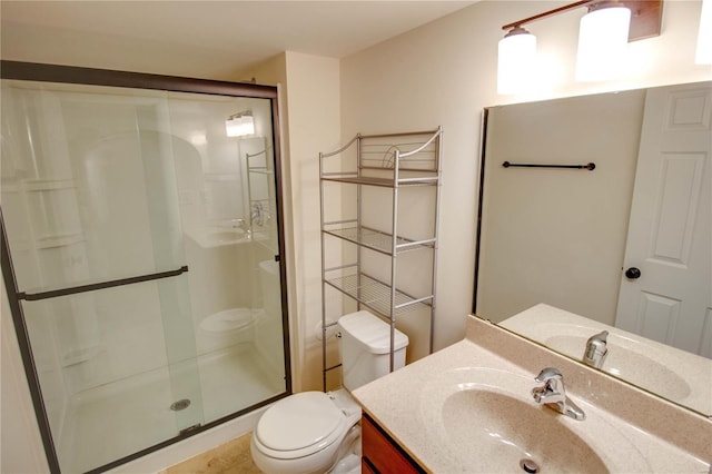 bathroom with toilet, a stall shower, and vanity