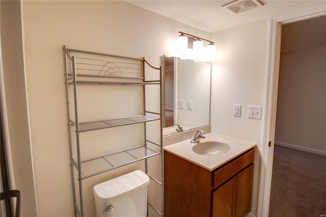 bathroom with baseboards, visible vents, vanity, and toilet