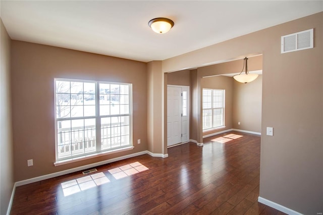 entrance foyer with a wealth of natural light, dark wood-style flooring, and visible vents