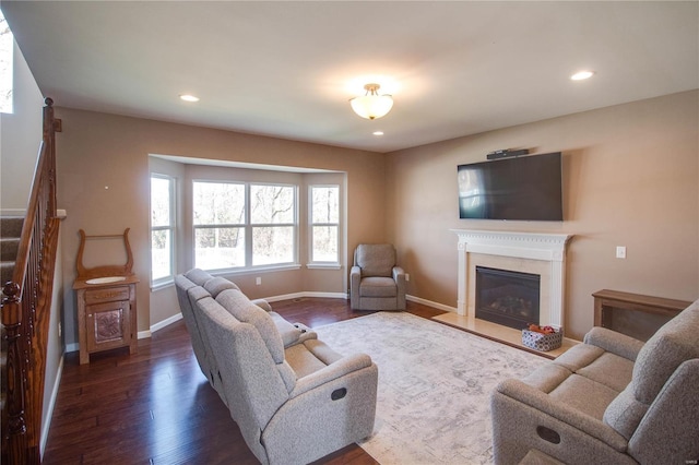 living room featuring dark wood finished floors, recessed lighting, stairway, a high end fireplace, and baseboards