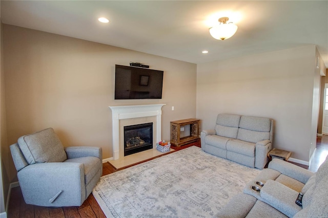 living area with recessed lighting, a fireplace, wood finished floors, and baseboards