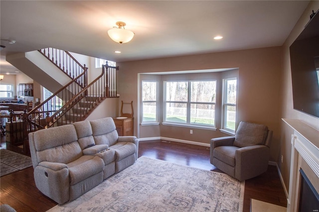 living area featuring stairway, wood finished floors, and baseboards