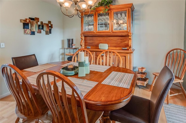 dining room featuring light wood-type flooring and a notable chandelier