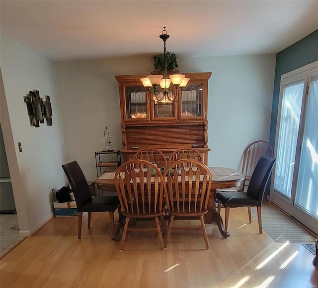 dining space featuring light hardwood / wood-style flooring and an inviting chandelier