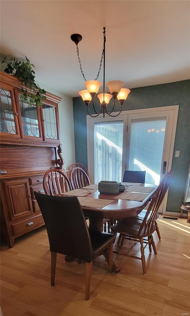 dining area featuring light hardwood / wood-style floors and a notable chandelier