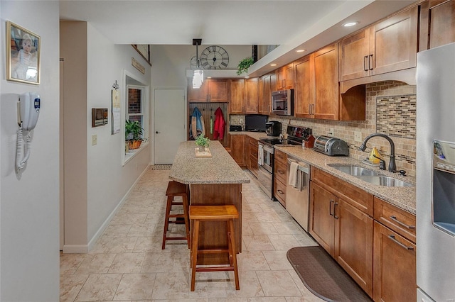 kitchen with a center island, sink, hanging light fixtures, stainless steel appliances, and decorative backsplash