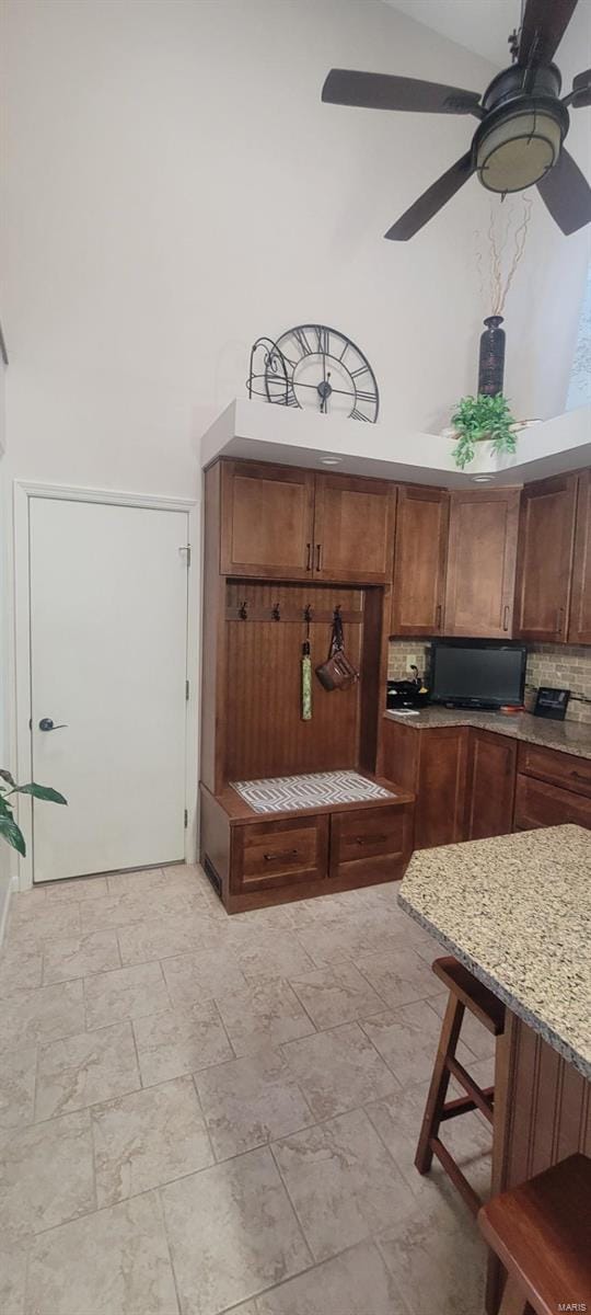 mudroom with a towering ceiling and ceiling fan