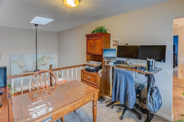 office area with a skylight and light colored carpet