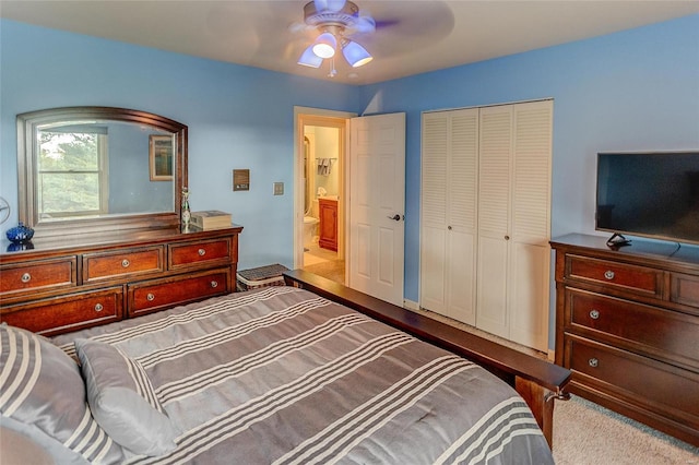 bedroom with ensuite bath, ceiling fan, a closet, and light colored carpet