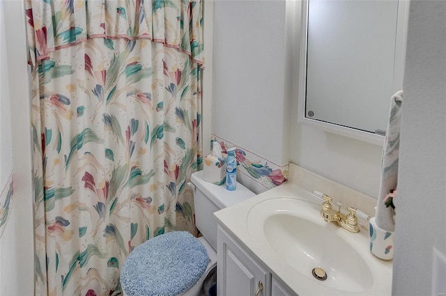 bathroom with vanity, a shower with shower curtain, and toilet