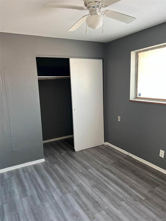 unfurnished bedroom with ceiling fan, a closet, and hardwood / wood-style flooring