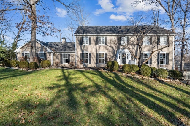 colonial inspired home featuring a front lawn