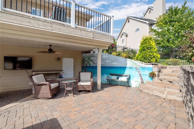 view of patio featuring a balcony, ceiling fan, and a swimming pool