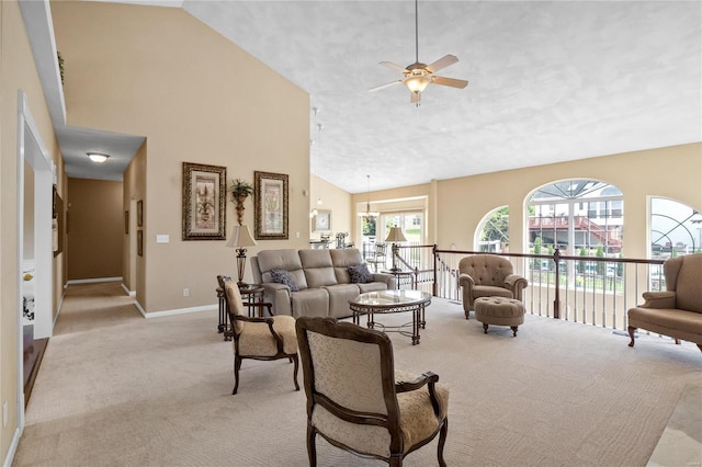 living room with ceiling fan, high vaulted ceiling, and light carpet