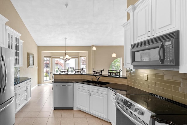 kitchen featuring appliances with stainless steel finishes, sink, an inviting chandelier, white cabinets, and hanging light fixtures