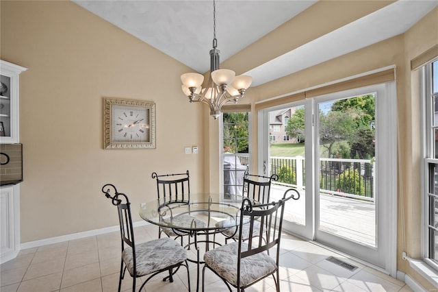 dining area with light tile patterned floors, vaulted ceiling, and an inviting chandelier