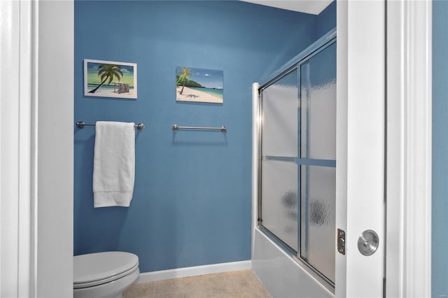 bathroom featuring tile patterned floors, enclosed tub / shower combo, and toilet