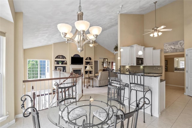 dining space featuring built in shelves, light tile patterned floors, and ceiling fan with notable chandelier