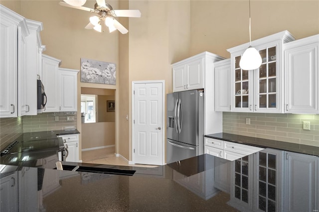 kitchen featuring decorative light fixtures, backsplash, stainless steel appliances, and white cabinetry