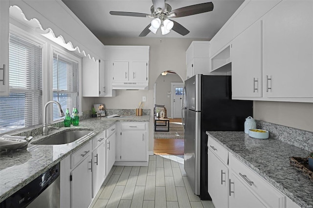 kitchen with ceiling fan, sink, white cabinetry, light stone countertops, and appliances with stainless steel finishes