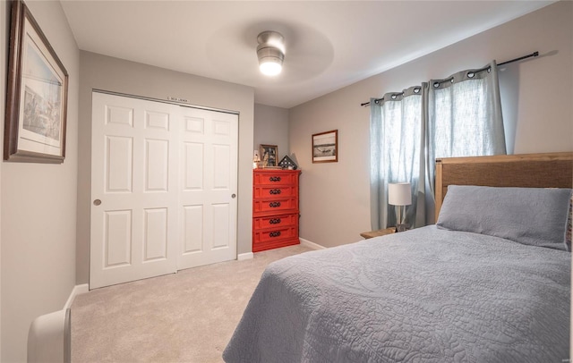 bedroom featuring ceiling fan, a closet, and light carpet