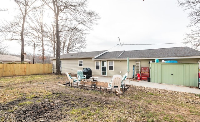 rear view of property featuring a shed and a patio