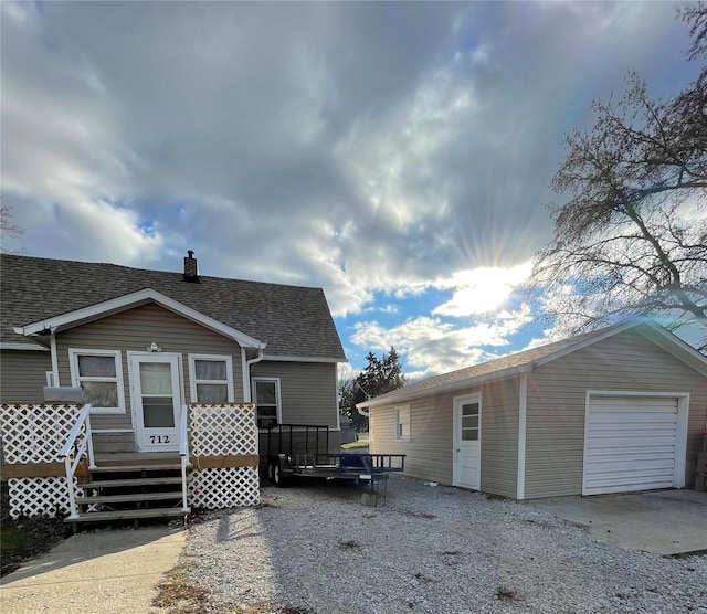 rear view of property with an outbuilding and a garage