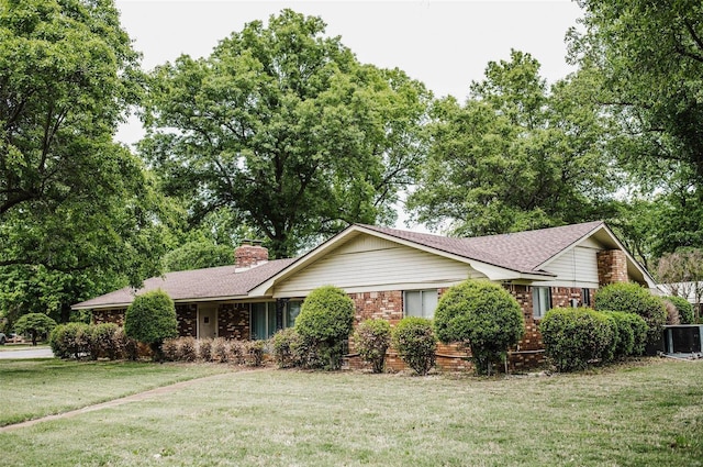 ranch-style house featuring cooling unit and a front yard