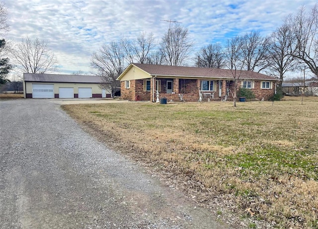 single story home featuring an outbuilding, a garage, and a front yard