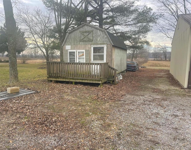 view of side of property with a deck and an outdoor structure