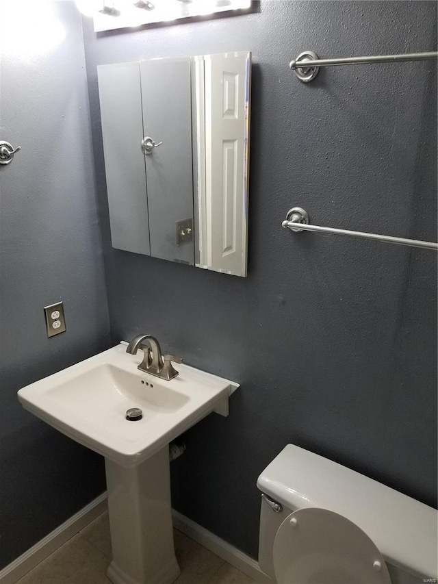 bathroom featuring sink, tile patterned flooring, and toilet