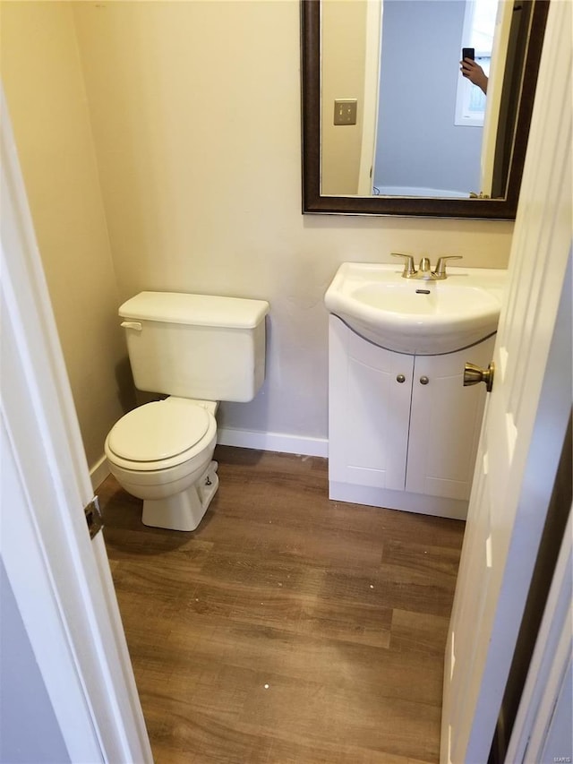 bathroom featuring toilet, vanity, and hardwood / wood-style flooring