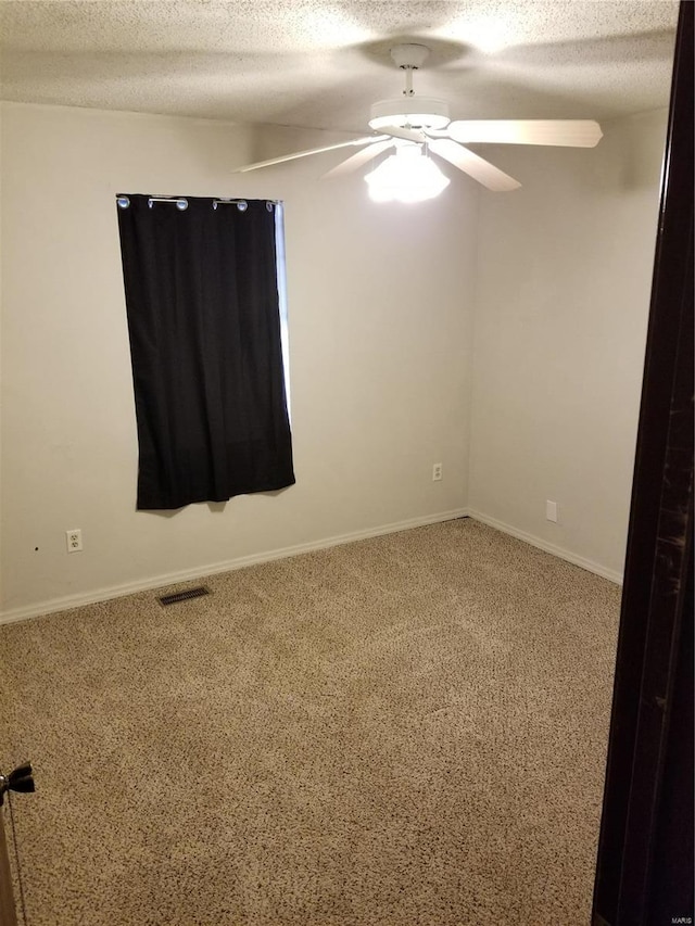 carpeted empty room with a textured ceiling and ceiling fan