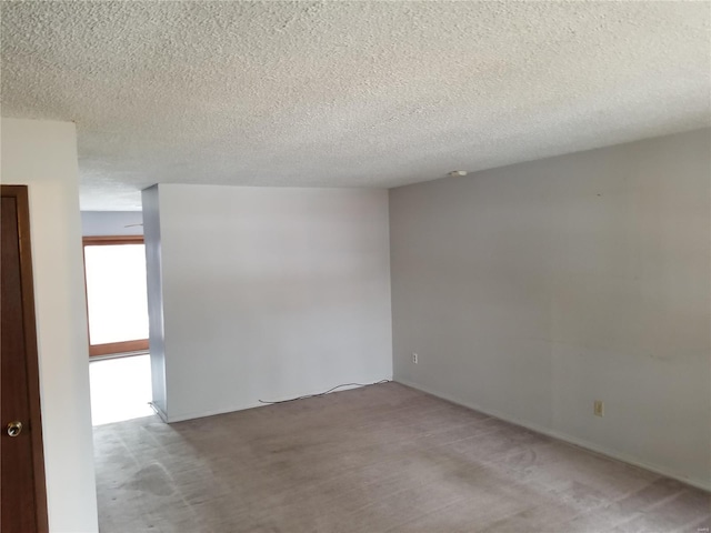 empty room featuring light colored carpet and a textured ceiling