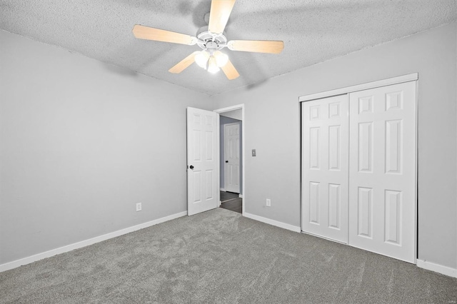 unfurnished bedroom with a closet, carpet flooring, a textured ceiling, and baseboards