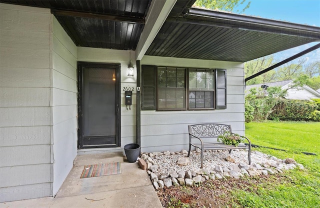 doorway to property featuring a lawn