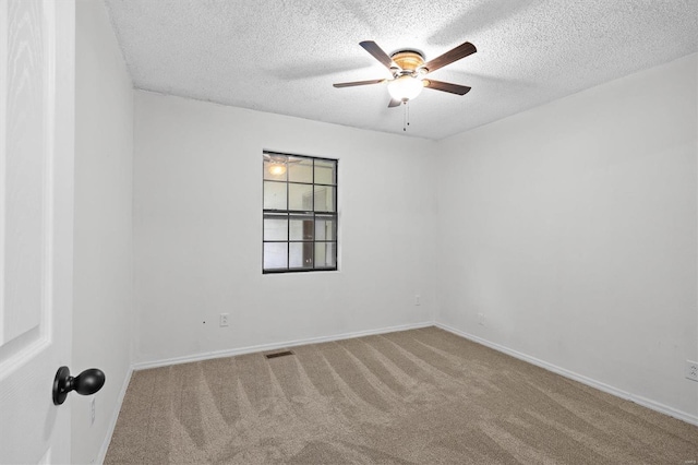 unfurnished room with baseboards, carpet, a ceiling fan, and a textured ceiling